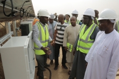 The REA Resident Engineer guiding the Hon. Minister through the Solar Farm