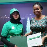 Damilola Ogunbiyi MD REA giving out certificate of attendance to one of the graduating STEM students
